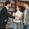 Agente immobiliare presenta una brochure aziendale a una coppia di clienti